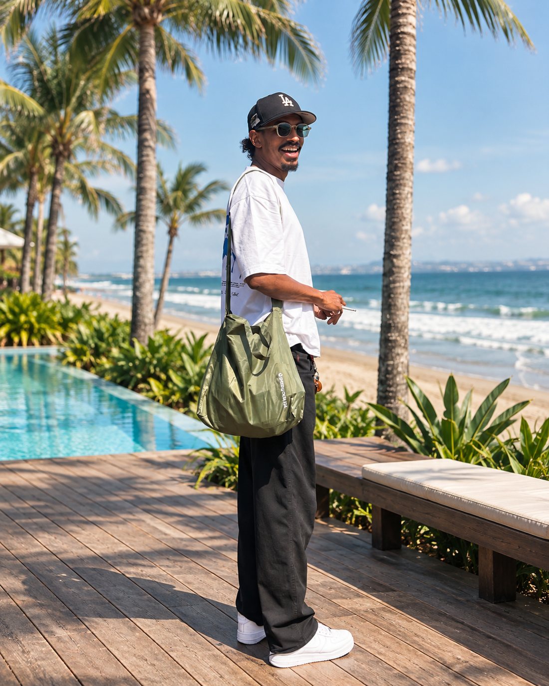 Omar Camara, founder of Carabiner, smiling on a seaside deck lined with palm trees